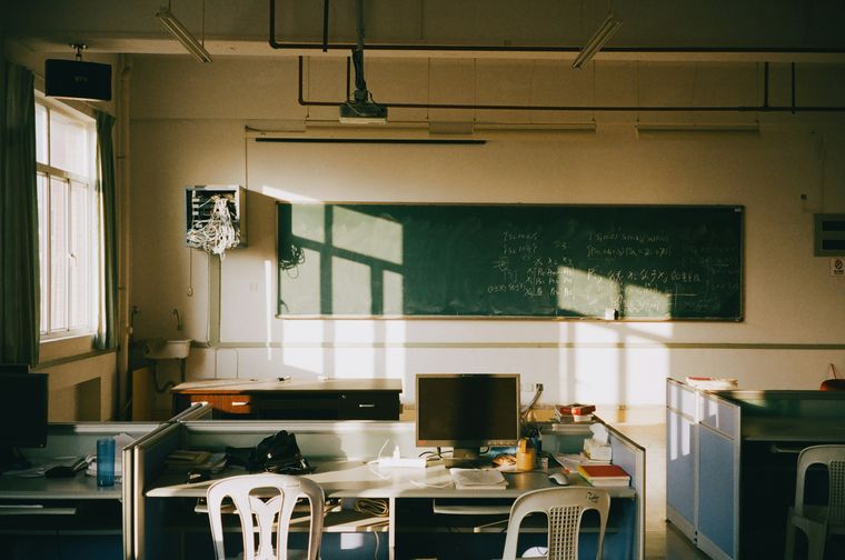 Afternoon sunlight falling across desks in an empty classroom