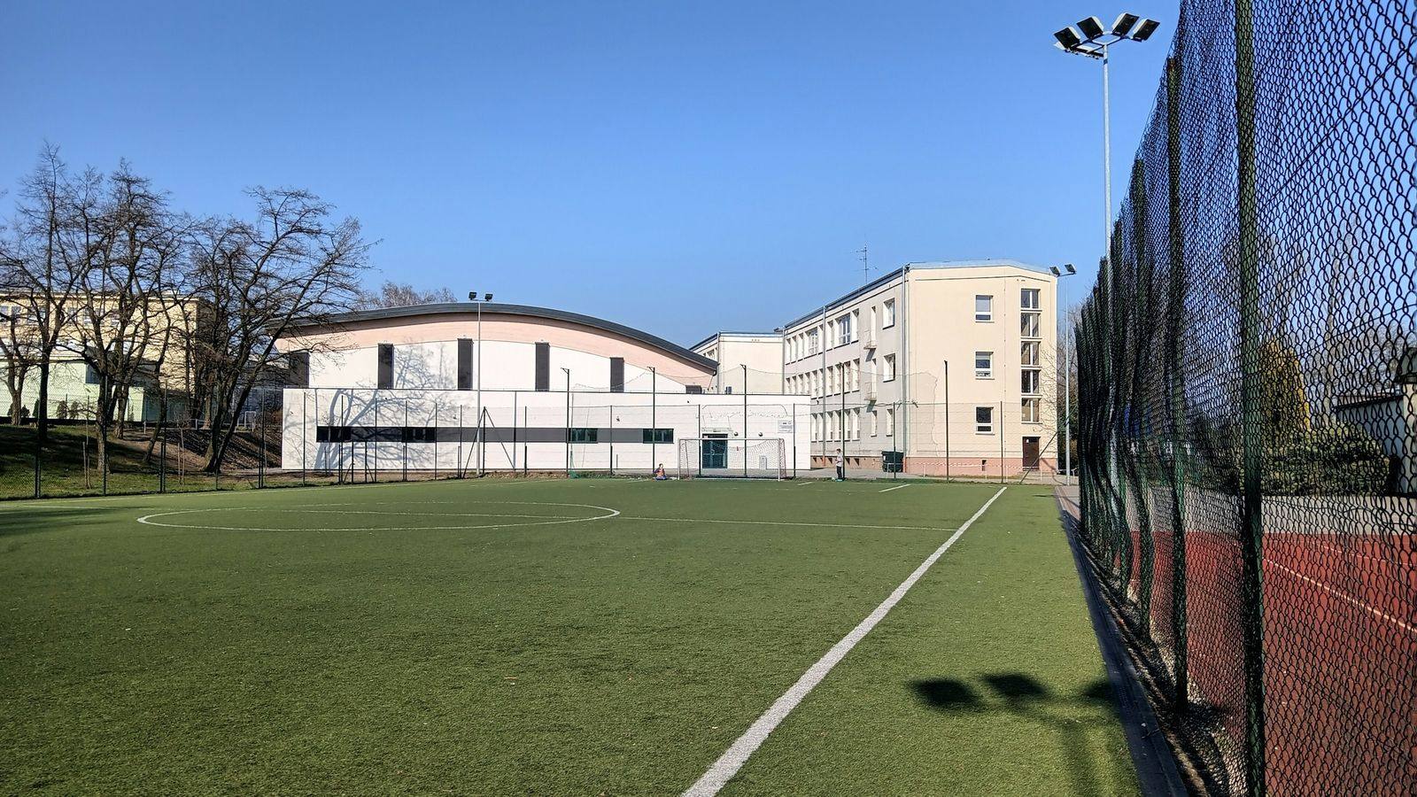 An all-weather sports field with goals in front of a school building